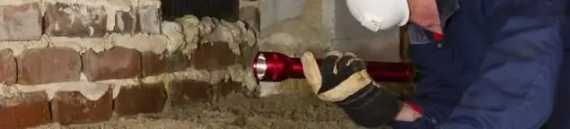 Pest control technician inspecting a crawl space for ant activity and entry points in Aurora, CO