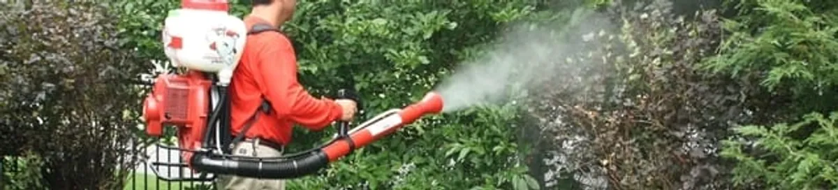 Mosquito control technician fogging shrubs and landscaping for mosquito treatment in Aurora, CO